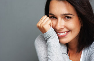 woman leaning on hand smiling, nice white teeth, Yorktown Heights, NY cosmetic dentistry